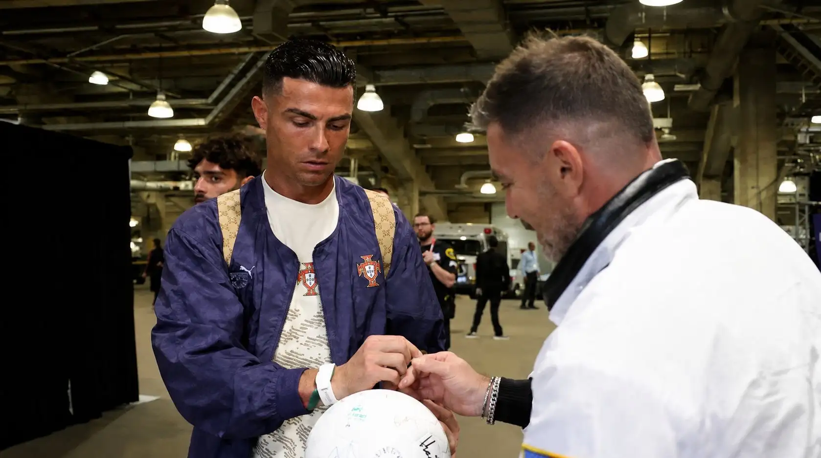 Cristiano Ronaldo poniendo su autógrafo en la Pelota del Mundial
